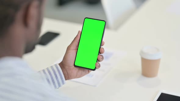 Rear View of African Man Using Laptop with Green Chroma Key Screen alt