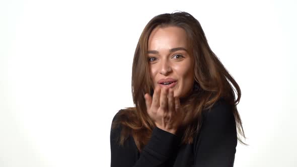 Beautiful Woman with Long Hair and in Black Sweater is Sending an Air Kiss  alt