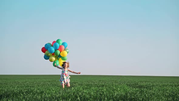 Happy Child Playing with Bright Multicolor Balloons 