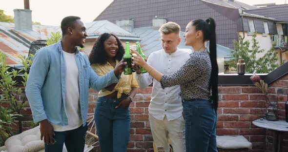 Friends which Have Terrace Party and Clinking Bottled Beer and Glasses with Wine alt