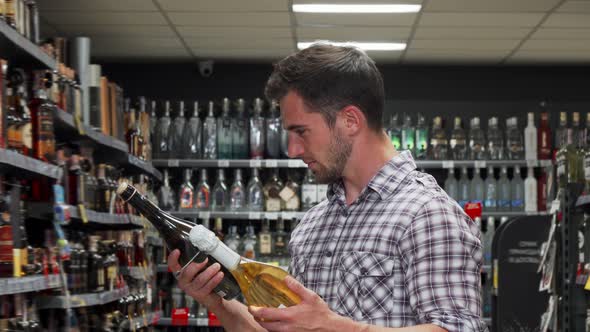 Handsome Young Man Smiling To the Camera Shopping for Wine alt