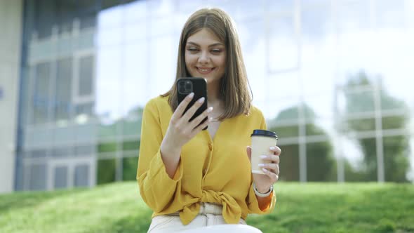 Attractive Woman Texting Message on Smartphone and Spending Time Outdoors