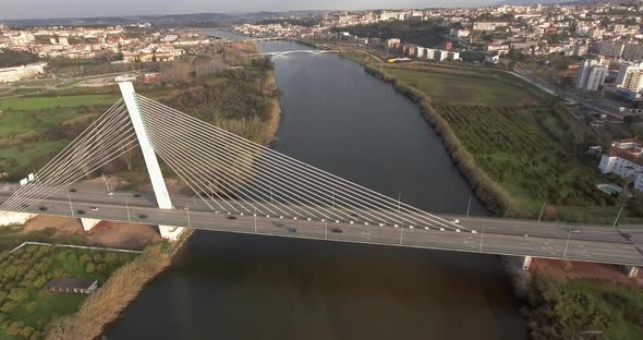 Aerial View Of Rainha Santa Isabel Bridge Crossing Mondego River In Coimbra, Portugal - drone pullba alt