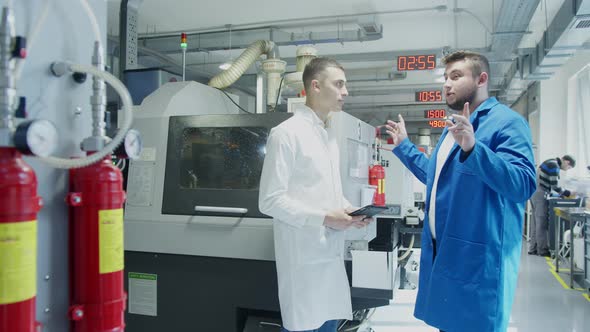 Industrial Employees with Tablet Inspecting Factory Equipment