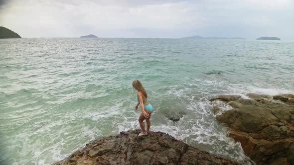 Woman Chill Relax Resting on Rock of Sea Reef Stone Stormy Cloudy Ocean alt
