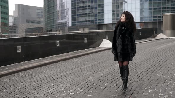 Sexy Lady Is Wearing Fur Coat and Leather Boots Is Walking on City Street at Winter Rich Woman alt