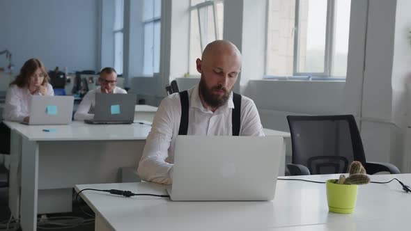 Focused Man in White Shirt Print on Laptop alt