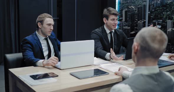 Employee of the Company Tells Colleagues About the Company's Plans and Smiles alt