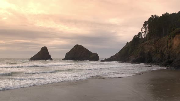 Flying over beach and towards rocks in the ocean alt