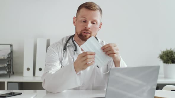 Male Doctor Showing and Explaining How to Wear Face Mask at Camera alt
