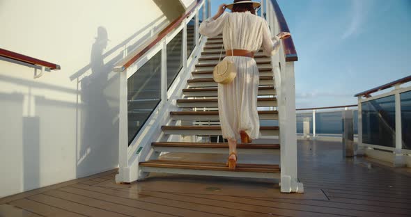 Young woman in a dress climbing the stairs. Shot on Black Magic Cinema Camera alt