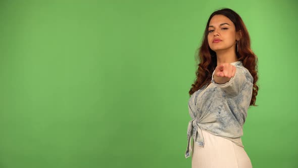 A Young Beautiful Caucasian Woman Points at the Camera and Nods  Green Screen Background