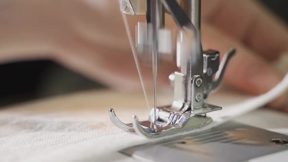 Woman Sews on a Sewing Machine Closeup of a Moving Needle Closeup alt