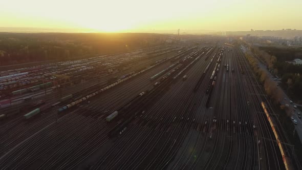 Aerial view, Railway sorting station at sunset. Many wagons and railway tracks at an industrial freight station