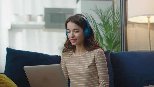 Happy Young Business Woman Wearing Headphones Talking to Laptop Making Distance Online Video