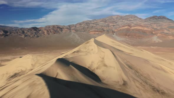 Aerial Speedy Shot Sand Dune Peak with Desert Wilderness on Background at Sunset alt