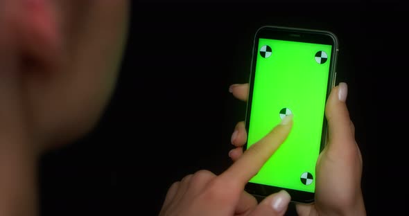Woman Using Mobile App on Green Screen Phone Swipes to the Left