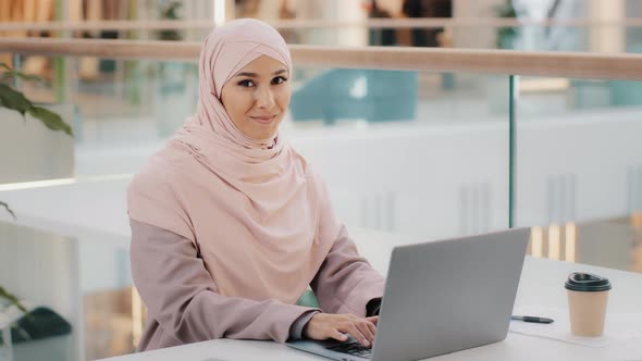 Happy Young Arab Businesswoman Sitting at Office Desk Typing on Laptop Working on Internet Checking alt