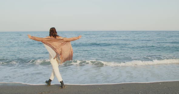 Young girl with black boots has fun on the beach near the sea in Italy alt