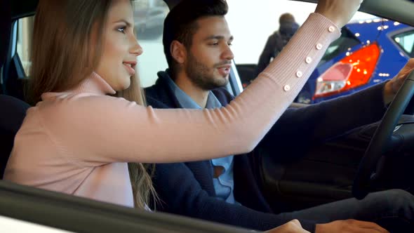 Man Points His Hand on the Console of the Car alt
