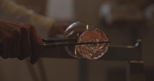 Professional glassblower working with glass at the workshop alt