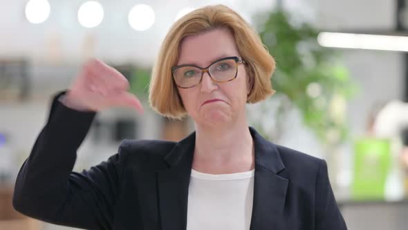 Portrait of Disappointed Old Businesswoman Doing Thumbs Down alt