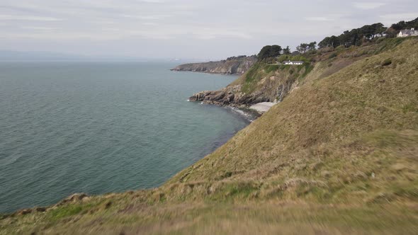 Aerial Reveal Of A Tiny Hidden Beach In Howth, Dublin, Ireland With Faraway View Of Bailey Cottage O alt