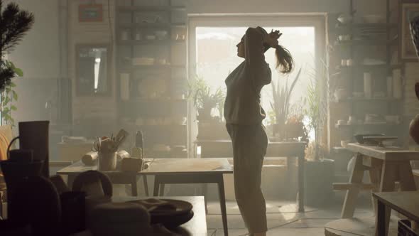 Woman Potter Is Getting Ready to Work In Pottery Workshop alt