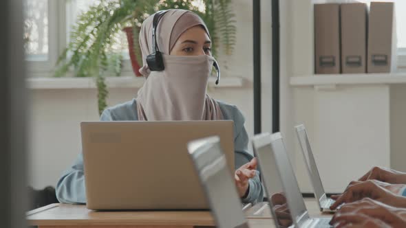 Muslim Woman in Headset Working in Call Center alt