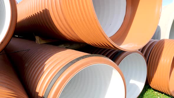 Closeup Dolly Shot of New Plastic Pipes and Tubes Stacked on the Building Site alt