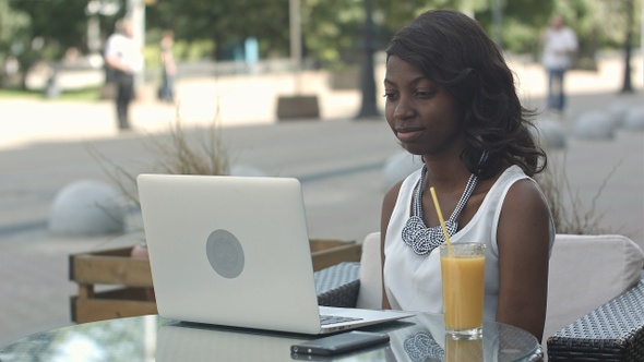 Young African Woman Sitting Alone in A Cafe Having a Videoconferance