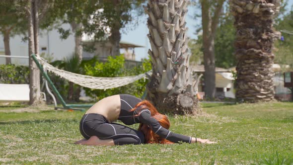 Doing yoga exercise in the garden. alt