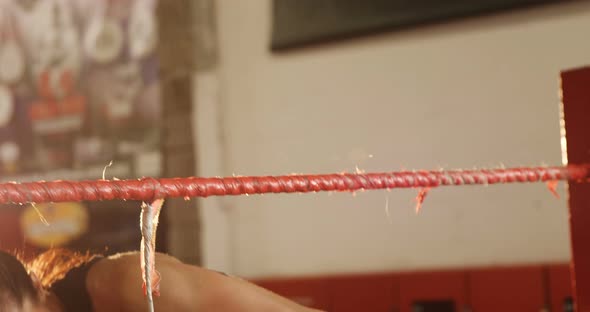 Tired female boxer getting out of ring alt