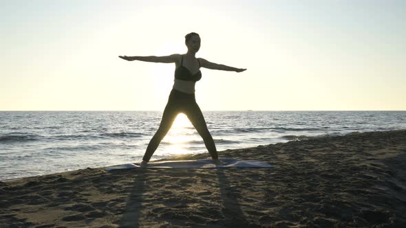 Young Caucasian Woman Practicing Yoga on the Beach Near Calm Sea.