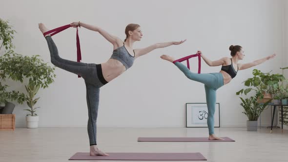 Two Young Women Using Yogic Belts during Yoga Class alt
