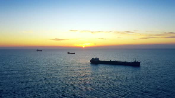Cargo Ships Off The Coast In Sunrise Or Sunset At Sea