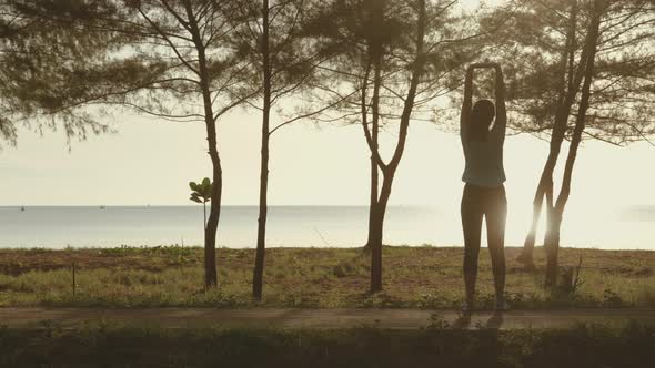 Asian cute girl She was walking and stretching before her morning run at the beach. alt