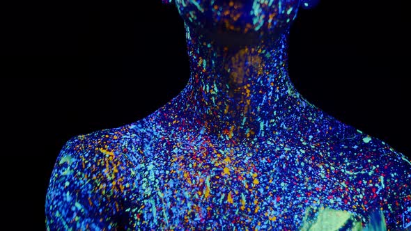 Man Painted with Fluorescent Paints Runs Thumb Over Neck Front View alt