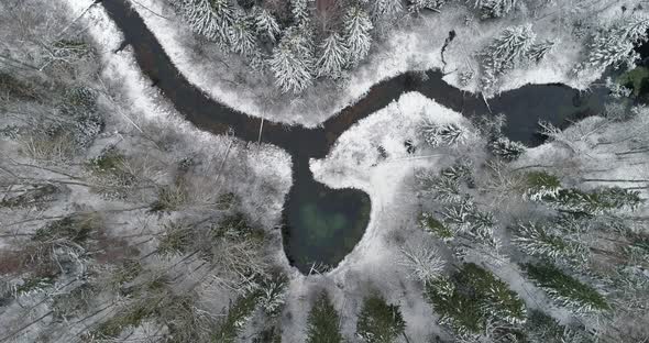 Heart Shape Spring Water Lake in Snowy Nordic Winnter Forest Aerial Descend alt