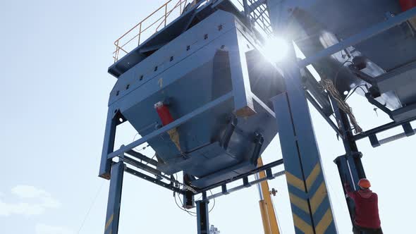 Worker Climbs on Metal Structure at Plant