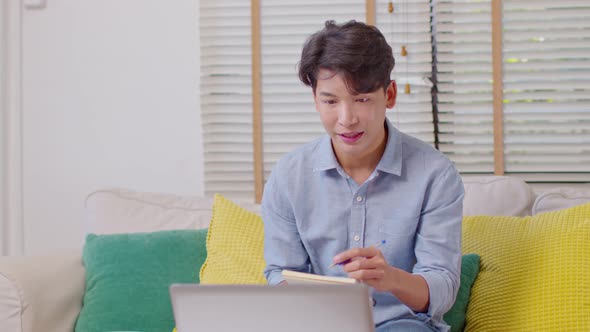 Asian businessman or freelancer writing business plan or customer order to notebook alt