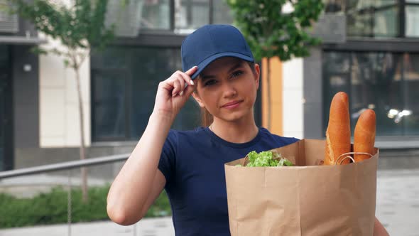 Close Up Food Delivery Woman Courier Holds Paper Bag with Groceries in Hand alt