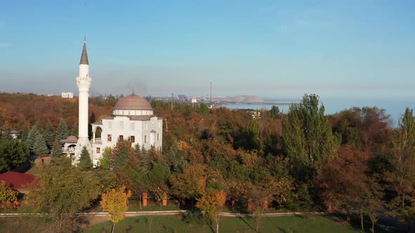 Aerial drone footage. Mosque among autumn trees