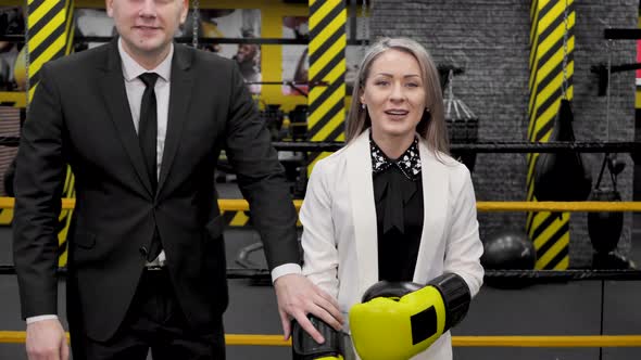 Colleagues a Man and a Woman in Business Suits and Boxing Gloves in the Ring