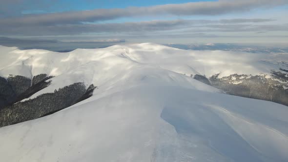 Amazing Aerial Flight Over Misty Mountain Range Meadows and Snow Covered Peaks in Winter Time