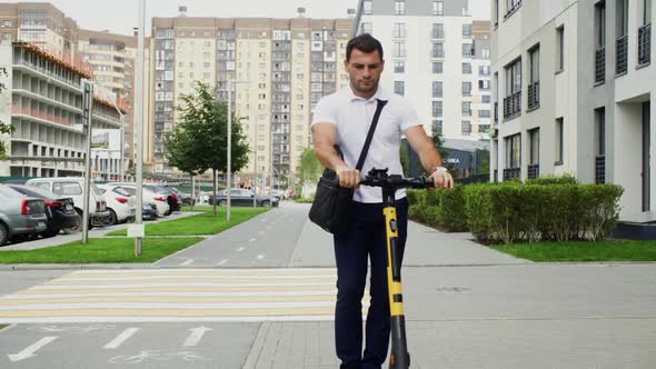 Man with Smartphone Finishing Rent of Escooter in Town alt