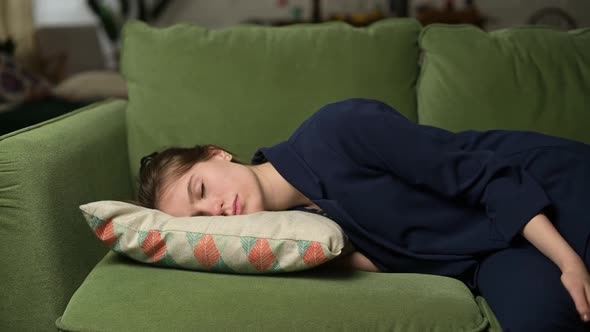 woman after work falls with a pillow on the sofa, she sleeps on the go alt
