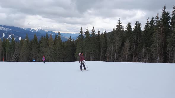 People skiing on the snowy slope of Bukovel ski resort in the Ukrainian Carpathian mountains.