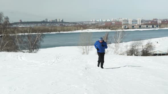 Man Running Up The Hill In Winter alt