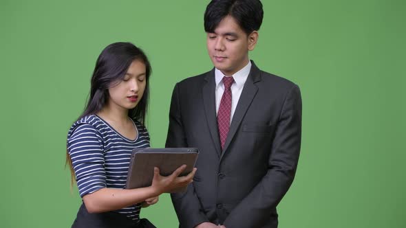 Young Handsome Asian Businessman and Young Asian Woman Working Together alt